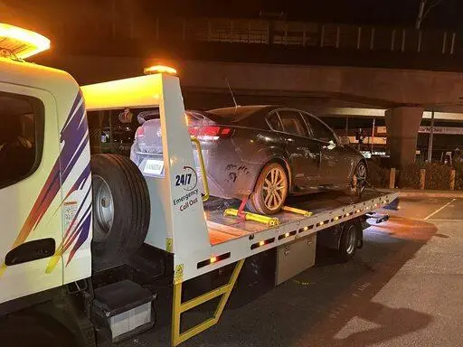 Professional flatbed tow truck safely loading a disabled vehicle during a 24/7 emergency towing service in Melbourne.