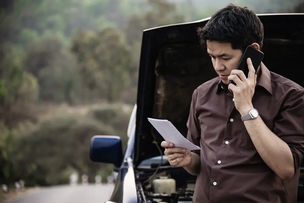 Driver calling for help beside a broken-down car
